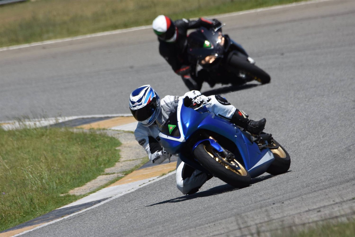 Warren leaning his Triumph Daytona 675 into a corner, knee down, at a 2016 track day