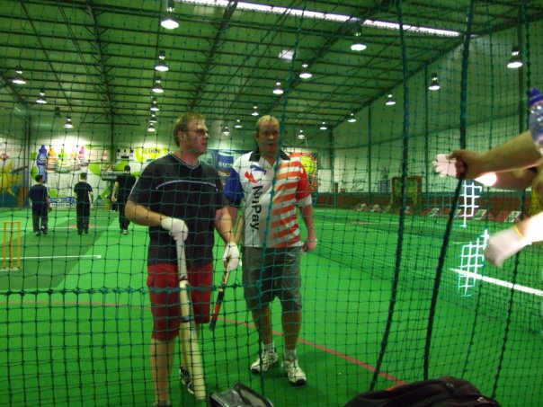 Warren padded up with a bat at indoor action cricket nets