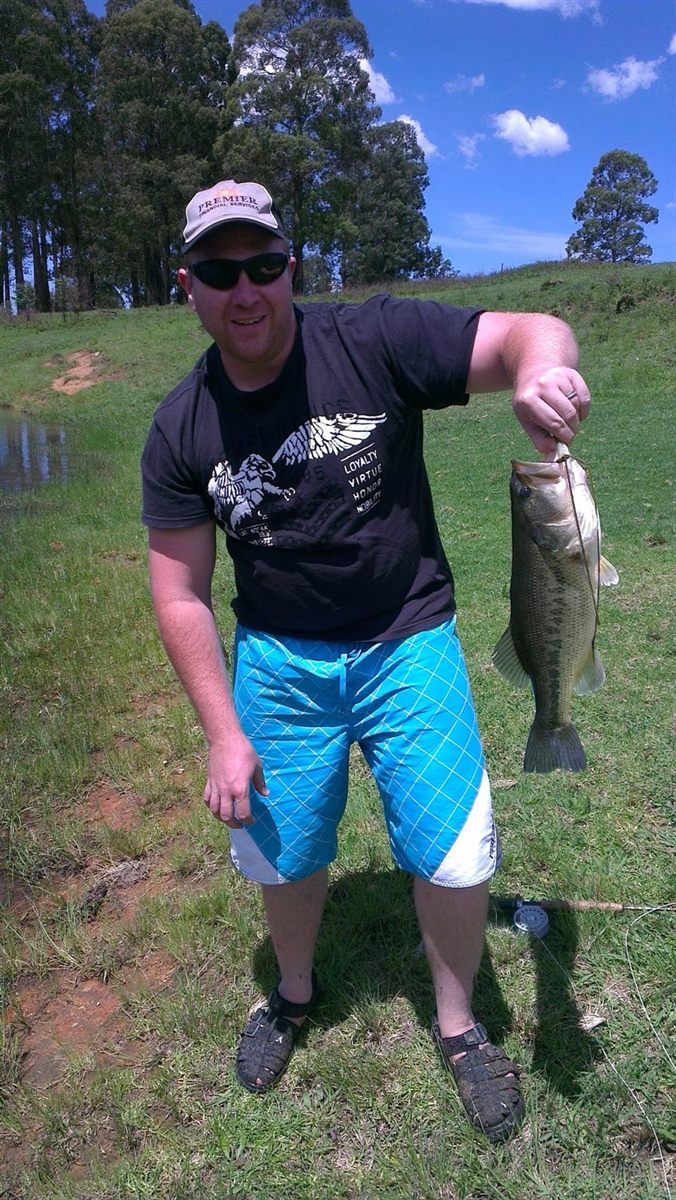 Warren holding a largemouth bass caught on a fly