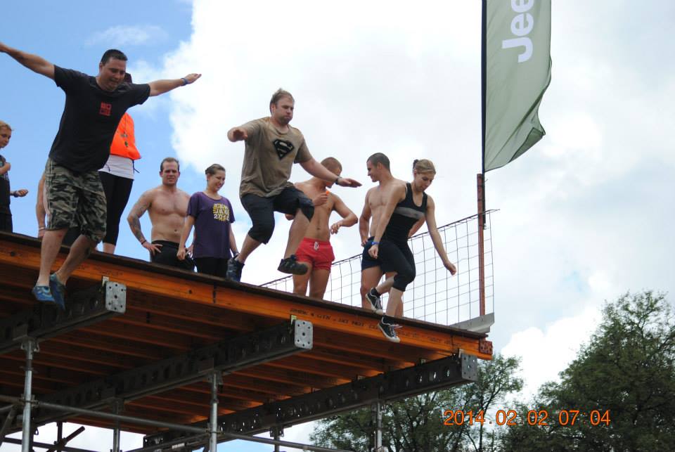 Warren crossing a high obstacle at a Warrior Race obstacle course event