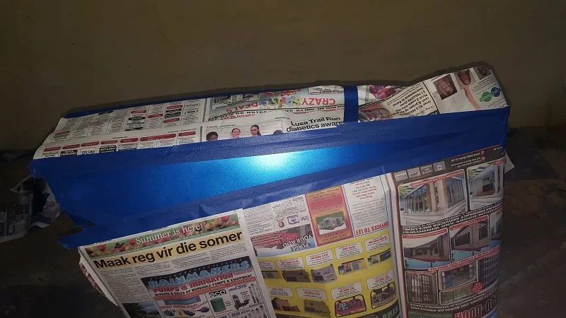 The belly panel wrapped in newspaper and tape, with a strip left exposed for the white dart